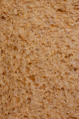 Slice of wholemeal brown bread background backdrop close up. Healthy food diet concept.