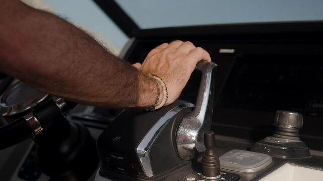 Slow motion close-up shot of a sailor pushing the yachts throttle fowards