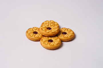 Strawberry jam biscuits on white background, decorated with a circular heart motif on their surface. High resolution photo.
