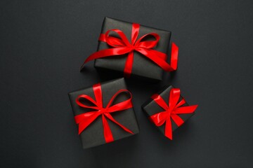 Beautiful gift boxes tied with bows on black background 