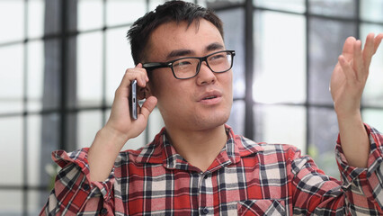 Young man remotely from the office talking on a mobile phone