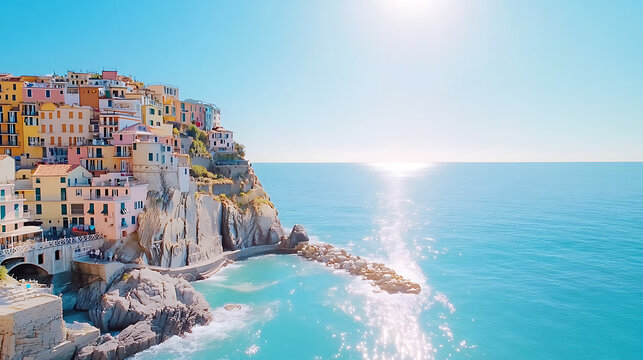 View of the colorful cliffside buildings in Manarola, Italy at sunset, with waves crashing against the rocks below and a clear blue sky above. - Powered by Adobe