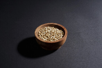 White peper in wooden bowl isolated on black background. High resolution photo.