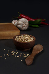 White peper in wooden bowl isolated on black background. High resolution photo.
