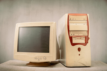 Old and obsolete personal computer set (PC) on grunge table and background