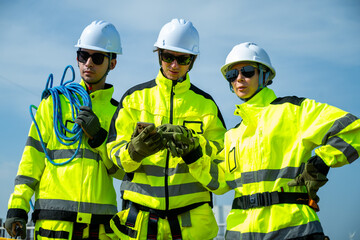 Fototapeta premium An engineer wearing safety gear closely inspects the base of a wind turbine in a renewable energy field.