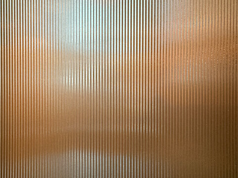 Texture of matt golden bronze fluted glass, or striped glass. Fluted glass is aesthetically beautiful in interior finishes and used for doors and partition. Seamless fluted glass panel.