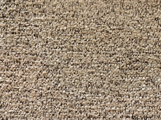 Close up texture of light brown beige tufted carpet fabric, made of cotton and hand tufted. Beige carpet fabric suitable for rug or carpet flooring. Seamless background fabric texture.