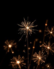 New Year's sparkler or fireworks on a black background, Hand holding burning Sparkler blast on a black bokeh background at night,holiday celebration event party,dark vintage tone