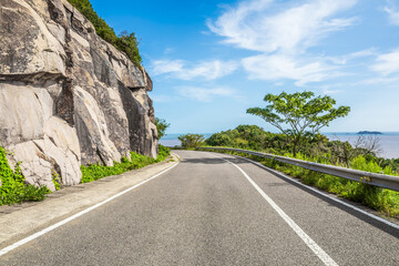 Asphalt highway road and mountain nature landscape by the sea. Road trip.