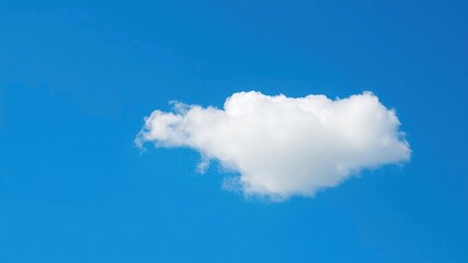 A single puffy cloud drifts lazily against a brilliant blue sky, white cloud, cloud formation, blue sky