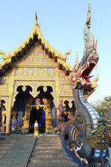 Russian tourist girl in Pavlovo Posad shawl and Wat Rong Suea Ten (Blue Temple) in Chiang Rai city, Thailand. Religious traditional national architecture. Landmark of Chiang Rai. Architectural fashion