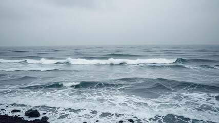 Fototapeta premium A stunning coastal landscape with black and white sea waves, seashore, sandy beach, atmospheric conditions