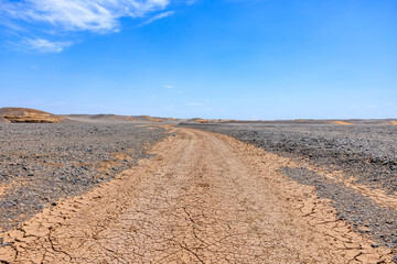 Desert dirt road natural landscape in Xinjiang, China. Road trip in no man's land. Outdoor natural background.