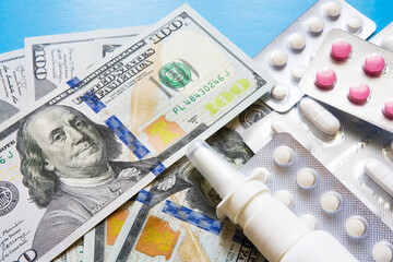 Dollars and medicines close-up on a blue background.
