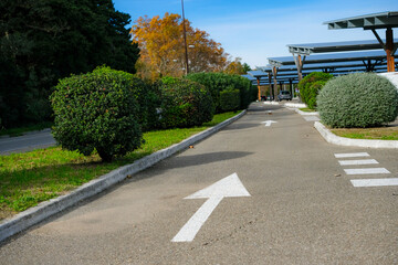 Orderly Landscaped Urban Environment with Solar Panels and Roadway with Directional Arrows. Copy Space. 