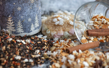 winter hot drink ingredient spiled  with spices, star-shaped and sugar  and  glass  cup turn over on  snowy background