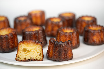 Caneles de bordeaux, traditional French sweet dessert with white table background, High quality photo