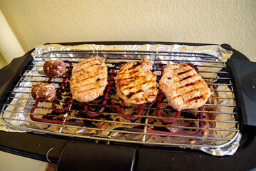 The meat is cooked on an electric grill