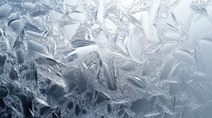 Close-up of intricate ice patterns on a glass surface, displaying delicate frost textures.