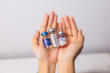 hands holding some of liquid medicine and vaccine in the clinic room. health and medical concepts.