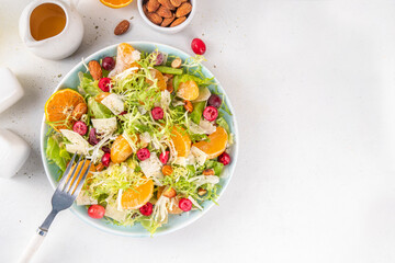 Salad bowl with lettuce, tangerines, nuts and cranberry