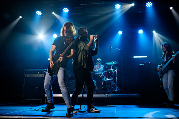 Rock band performing live on stage with energetic musicians