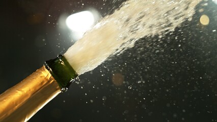 Celebration theme with splashing champagne on black background.