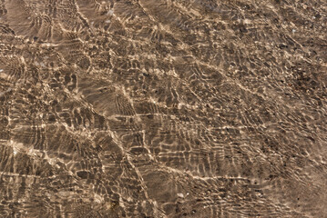 SEAWATER AND SAND - Grainy surface of a natural mineral under water
