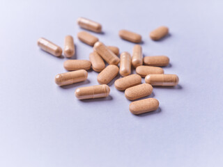 Ashwagandha (Withania somnifera) tablets and capsules on paper background. Soft focus.. Close up. Copy space.	