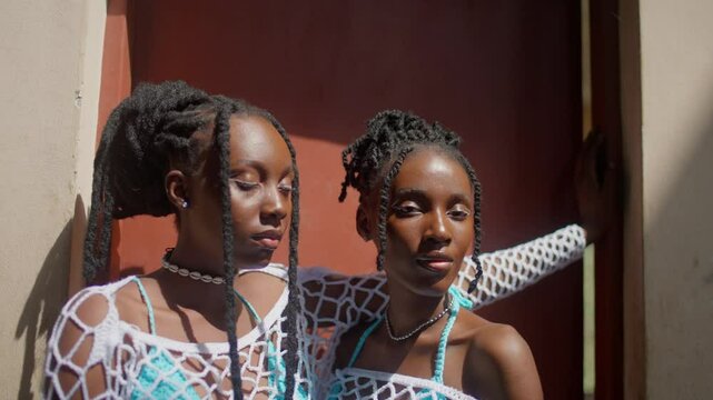 Two black models pose wearing crochet outfits, static shot