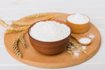 Flat lay of Wheat flour in wooden bowl with wheat spikelets on colored background. world wheat crisis