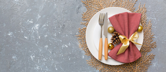Naklejka premium Christmas table place setting with christmas decor and plates, kine, fork and spoon. Christmas holiday background. Top view with copy space