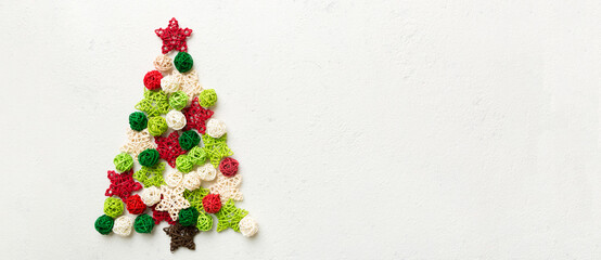 Christmas tree made from colored handmade ball decoration on colored background, view from above. New Year minimal concept with copy space