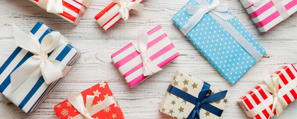 A lot of Christmas gift boxes in colored paper decorated on table, Top view close up. Many present...