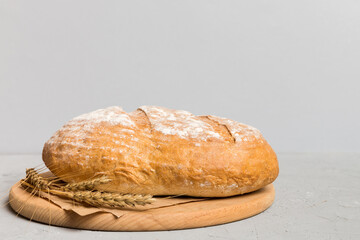 Freshly baked bread on cutting board against white wooden background. perspective view bread with copy space