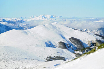 View towards Durmitor from the top of Troglava in the Biogradska Gora National Park. Winter nature in Montenegro: landscape with snow, mountains and clouds, taken during a visit to the Kolasin 1600