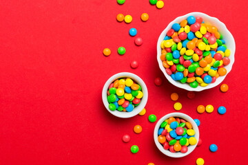 different colored round candy in bowl and jars. Top view of large variety sweets and candies with copy space
