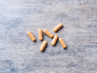 Korean Ginseng capsules. Concept for a healthy dietary supplementation. Wooden background. Top view. Soft focus. Close up.	