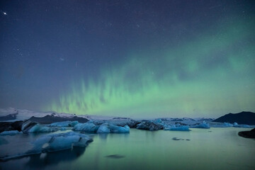 Fototapeta premium Aurora boreal en islandia con icebergs de noche