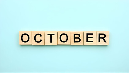 OCTOBER month sign on wooden cubes with blue background.