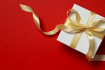 Beautiful gift box tied with bow on color background 