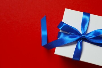 Beautiful gift box tied with bow on color background 