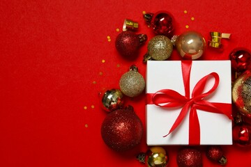 Beautiful gift box tied with bow Christmas decorations, confetti on color background 