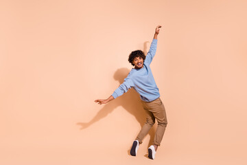 Full body photo of positive cheerful guy wear blue shirt trousers stand on tiptoes dancing having...