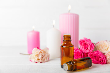 Rose essential oil on a textured background.Roses and a bottle of rose perfumed water.Aromatherapy treatment. Beauty concept. Spa procedure.Natural organic oil.Anti-stress,detox relax.Place for text