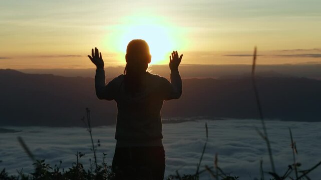  Silhouette of Person hands open palm up worship God helping repent catholic easter lent mind pray Christian religion.  prayer woman worship God in the morning with sunrise.