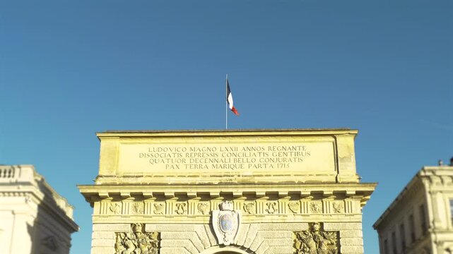 Arc de Triomphe de Montpellier situer dans le sud de la France avec drapeau fran&ccedil;ais flottant au vent.