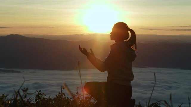  Silhouette of Person hands open palm up worship God helping repent catholic easter lent mind pray Christian religion.  prayer woman worship God in the morning with sunrise.
