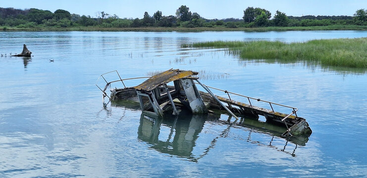 Panorama of old abandoned fishing boat is located in the river of the town of Bibione.